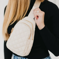 Women's sling cream colored puffer bag with gold zipper